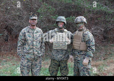 Marine Corps Sistemi di comando Capt. Christopher Kiely, Justin Miller e il Mag. Paul Lee agiscono come la rivelazione del bersaglio decoy in un allestimento di fanteria sfida esercizio di valutazione nel mese di dicembre a bordo Marine Corps base Quantico, Va. MCSC ingegneri effettuavano la rivelazione del bersaglio speed trials con la lotta contro gli istruttori della Scuola di fanteria-Est per valutare quanto velocemente gli istruttori potrebbe rilevare il decoy, che erano rifiniti in variando il camuffamento ingranaggio. (U.S. Marine Corps foto di Ashley Calingo) Foto Stock