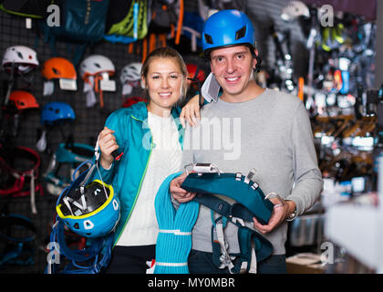 Giovane uomo e donna nel negozio di sport la scelta di arrampicata attrezzature Foto Stock