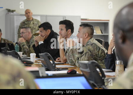 Hilo, Hawaii -- (da sinistra a destra) Distretto 1 Stato Senatore Kaiali'i zona di Kahele, Stati Uniti senatore da Hawaii Brian Schatz, e Joint Task Force 5-0 comandante generale, Briga. Gen. Kenneth S. Hara, sedersi con la JTF 5-0 personale per un aggiornamento situazionale 29 maggio 2018, illustrando la Guardia Nazionale operazioni di risposta al 24 fessure di lava che si sono rotti a partire dal maggio 3. Dal 3 maggio più di 200 Nazionale soldati di guardia e Airman sono state attivate per supportare il costante sostegno a sforzi nel e intorno al quartiere di Puna sulla Grande Isola delle Hawaii. Foto Stock