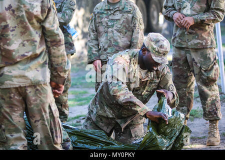 Sgt. Owayne Henry, san Tommaso, Giamaica native, combattere medic con il primo squadrone, 2° reggimento di cavalleria, insegna a un gruppo di soldati come preparare un incidente durante il combattimento ancora di salvezza la formazione con gruppo di combattimento della Polonia a Bemowo Piskie Area Formazione, Polonia, 30 maggio 2018. Gruppo di combattimento della Polonia è un luogo unico e multinazionale di coalizione di Stati Uniti, Regno Unito, croato e soldati rumeni che servono con il polacco della XV Brigata meccanizzata come una forza di dissuasione a sostegno della NATO in avanti rafforzata presenza. (U.S. Esercito foto di Spc. Hubert D. Delany III) Foto Stock