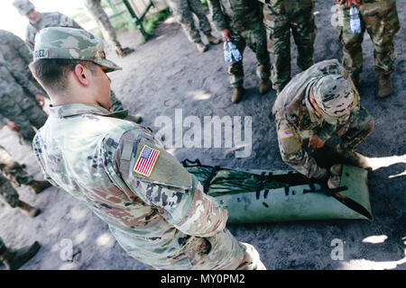 Sgt. Elias Rodriguez (centrale), Whittier, California native, combattere medic con il primo squadrone, 2° reggimento di cavalleria, supervisiona un soldato di preparare un incidente durante il combattimento ancora di salvezza la formazione con gruppo di combattimento della Polonia a Bemowo Piskie Area Formazione, Polonia, 30 maggio 2018. Gruppo di combattimento della Polonia è un luogo unico e multinazionale di coalizione di Stati Uniti, Regno Unito, croato e soldati rumeni che servono con il polacco della XV Brigata meccanizzata come una forza di dissuasione a sostegno della NATO in avanti rafforzata presenza. (U.S. Esercito foto di Spc. Hubert D. Delany III) Foto Stock