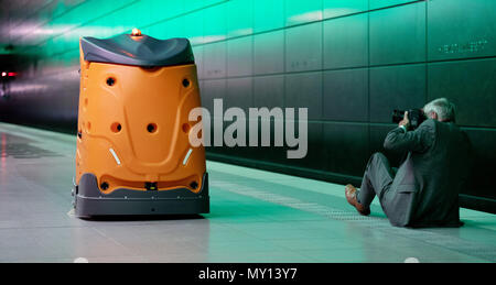 05 giugno 2018, Germania Amburgo: un uomo prende una foto della pulizia autonoma robot chiamato 'Taski Swingobot 2000' durante la sua presentazione presso la stazione della U-Bahn "Hafencity Universitaet'. Foto: Daniel Reinhardt/dpa Foto Stock