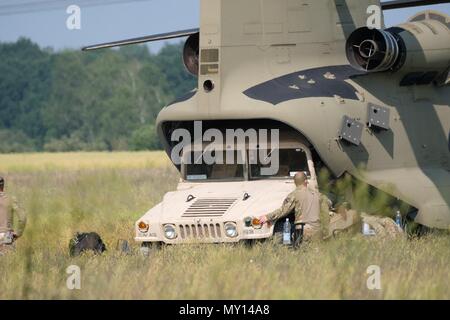 05 giugno 2018, Germania, Delitzsch: un veicolo fuoristrada essendo caricato off a forze armate USA elicottero che forza-sbarcato in un campo vicino alla città di Beerendorf vicino a Delitzsch e caricato su un altro. Il 'Chinook' aeromobile ha dovuto eseguire un atterraggio forzato sul campo ed è destinato a subire riparazioni sul posto nei prossimi giorni. Il danneggiato elicottero's cargo è di essere volato fuori dell'area. Foto: Sebastian Willnow/dpa-Zentralbild/ZB Foto Stock