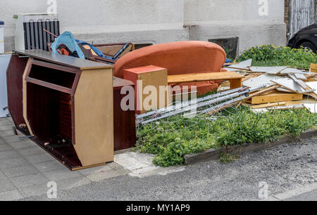 Rifiuti ingombranti con armadi, un divano e mobili sul prato di fronte ad un edificio di appartamenti, Germania Foto Stock