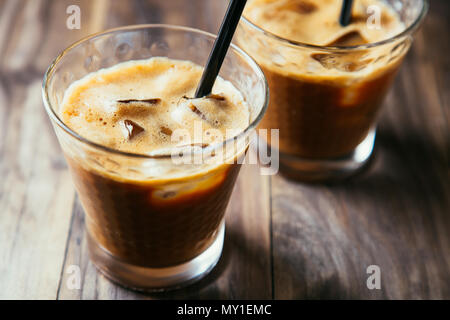 Due bicchieri di caffè ghiacciato latte con cannucce su una tavola in legno rustico Foto Stock