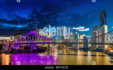 Vivace notte e giorno orario panorama della città di Brisbane con luci viola sul Ponte Story, Australia Foto Stock