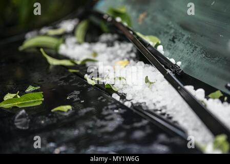 Grandi grandine sfere di ghiaccio sul cofano auto dopo una forte tempesta estiva Foto Stock