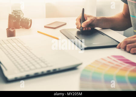 Graphic designer al lavoro in ufficio a lavorare con il disegno digitale compressa Foto Stock