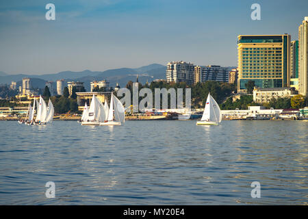 Sochi, Russia-October 8, 2016: regata velica di yacht bianco sullo sfondo della moderna città termale. Foto Stock