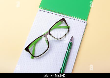 Gli accessori business sul desktop: notebook, agenda, penna stilografica, bicchieri. Macro con blur e soft focus. Foto Stock