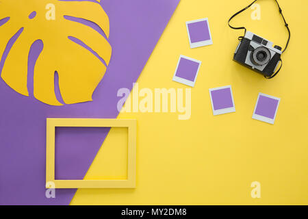Foglia sul layout di violetta e fotocamera su sfondo giallo con telaio vuoto e foto Foto Stock