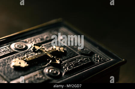 Antica e preziosa la Bibbia con golden cross vicino, la religione e la spiritualità concept Foto Stock