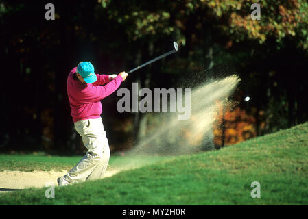 Un giocatore di golf di blasti fuori da una trappola di sabbia in Foxboro, Massachusetts, STATI UNITI D'AMERICA Foto Stock
