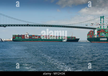 La Nave portacontainer, SEAMAX New Haven, coadiuvato dal trattore rimorchiatori sotto il Vincent Thomas Bridge nel porto di Los Angeles, California, USA. Foto Stock