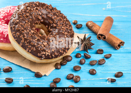 Ciambella di cioccolato con sparsi grani di caffè vicino sul tavolo Foto Stock