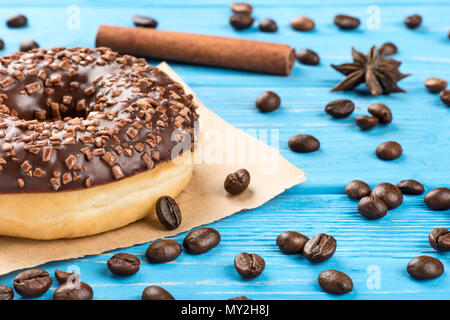 Al delizioso cioccolato ciambella con fagioli sparsi sul tavolo di close-up Foto Stock