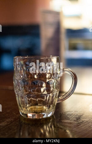 La birra vuota in un vetro satinato spesso chiamato un bicchiere con manico o vetro increspato Foto Stock