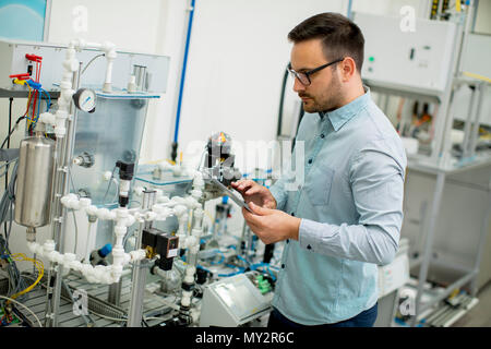 Bel giovane uomo nel laboratorio elettronico Foto Stock