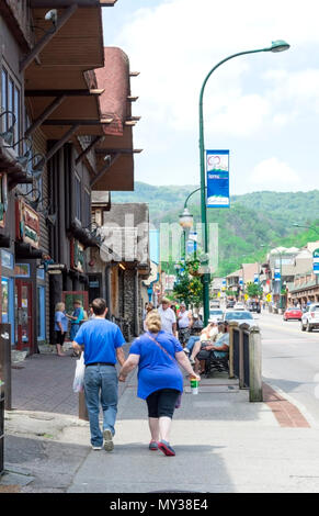 Gatlinburg,TN, Stati Uniti d'America - 14 Maggio 2018: colpo verticale delle persone che camminano verso il basso la striscia di Gatlinburg verso alcune delle bellissime colline nelle Smoky Mountains Foto Stock