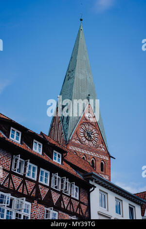 Torre di San Johannis chiesa di Luneburg e un vecchio a struttura mista in legno e muratura in mattoni rossi casa di fronte. Germania Foto Stock