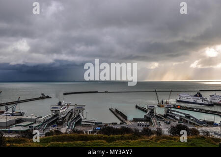 Brutto tempo oltre il Canale della Manica e il porto di Dover. Condizioni meteorologiche estreme. Le tempeste. In caso di pioggia. Piove. Crepuscolo. Il tramonto. P&O traghetto in retromarcia al dock Foto Stock