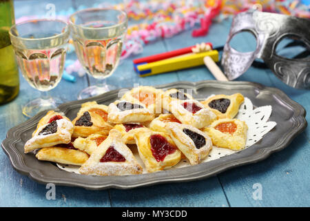 In casa hamantaschen cookie,noise maker e maschera, per felice Purim ebraico partito per le vacanze Foto Stock