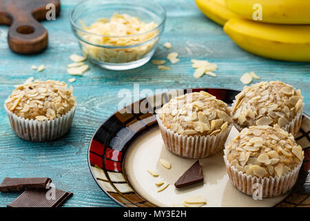 Zucchero gustosi muffin con mandorle noci e cioccolato blu su sfondo di legno Foto Stock