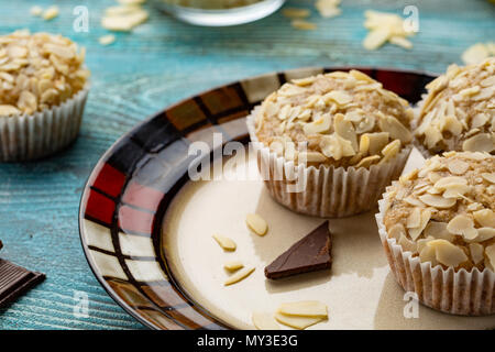 Zucchero gustosi muffin con mandorle noci e cioccolato blu su sfondo di legno Foto Stock