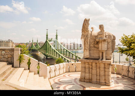 Budapest, Ungheria - 6 Giugno 2017: Statua di Stefano I di Ungheria (Re Santo Stefano) con un cavallo sulla collina Gellert, con una vista del Ponte della Libertà Foto Stock