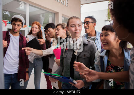 Studenti del college guardando le informazioni pubblicate sul campus Foto Stock