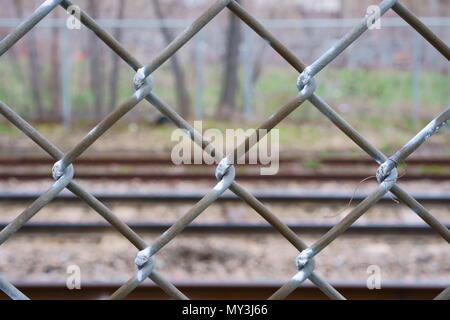 Una recinzione lungo un binario ferroviario. Foto Stock