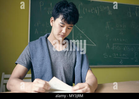 Giovane uomo che studiano in classe math Foto Stock