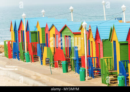 Pittoresca spiaggia di capanne in fila su di una spiaggia di sabbia bianca di Muizenberg sotto un cielo di estate blu. Muizenberg, Cape Town, Sud Africa. Foto Stock