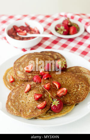 Utile colazione a base di frittelle di farina di semi di lino e di fragole e salsa di miele. Messa a fuoco selettiva. Foto Stock