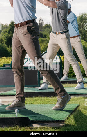 Vista parziale di un gruppo di uomini a giocare a golf insieme al campo da golf Foto Stock