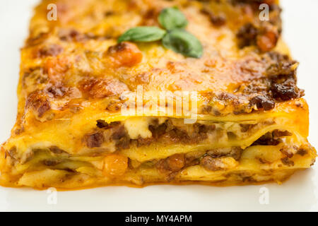 Le lasagne italiane con le carni bovine macinate, Ragù alla Bolognese e basilico su piastra bianca Foto Stock