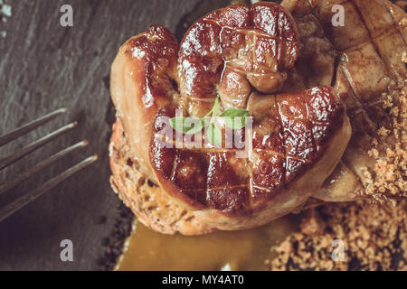 Cucina francese frittura di Foie Gras con coulis di mango su sfondo scuro Foto Stock