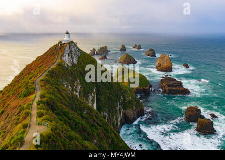 Nugget Point Lighthouse con sunrise, Isola del Sud, Nuova Zelanda Foto Stock