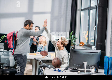 Felici gli uomini si salutano in un ufficio moderno Foto Stock