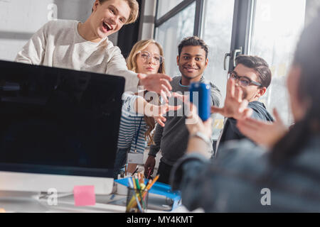 Persone raggiungono le mani per la banca con il drink in ufficio Foto Stock