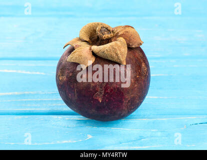 Frutti maturi mangosteen su un tavolo blu Foto Stock