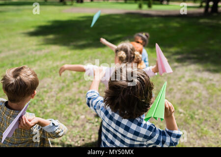 Carino figlioli gettando piani della carta in posizione di parcheggio Foto Stock