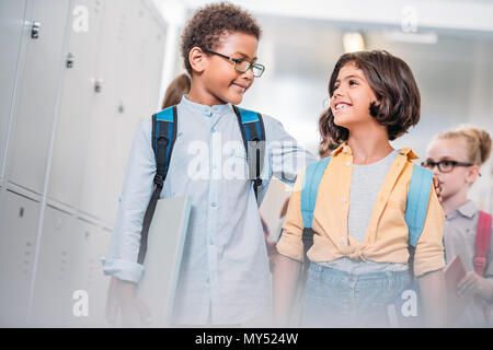 Il fratello di una sorella che abbraccia a scuola e camminare attraverso il corridoio Foto Stock