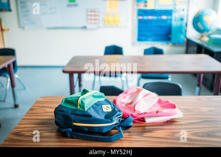 Zaini posa sulla scrivania in aula scolastica Foto Stock