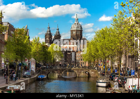 San Nicola Basilica vista. Giornata di Primavera in Amsterdam con ponte di barche e biciclette Foto Stock
