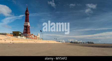 Blackpool, Inghilterra, Regno Unito - 1 Agosto 2015: i turisti a piedi lungo le sabbie di Blackpool Beach sotto la mitica Torre di Blackpool e Blackpool North Pier su Foto Stock