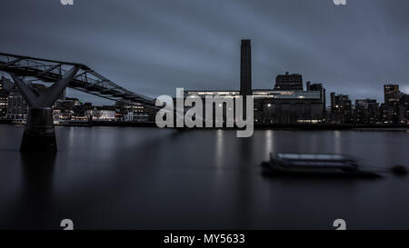 London, England, Regno Unito - 3 Aprile 2018: Il fiume Tamigi scorre sotto il Millennium Bridge al di fuori della galleria d'arte Tate Modern e Shakespeare's Globe Theatr Foto Stock