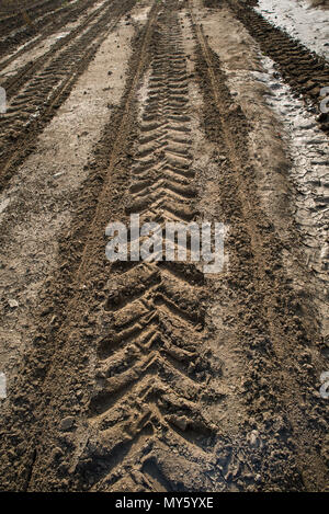 Tracce dalle ruote del trattore su un campo arato. Foto Stock