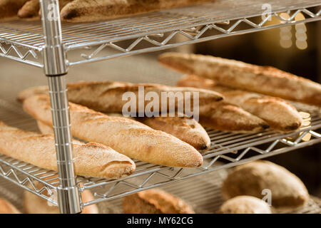 Ripiani con pane appena sfornato sulla fabbricazione di cottura Foto Stock