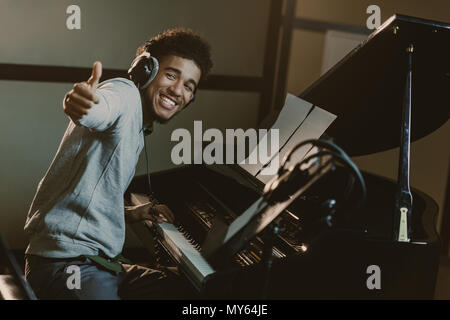 Felice giovane pianista che mostra il pollice in alto Foto Stock